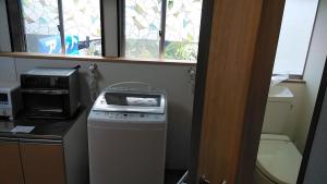 a kitchen with a washing machine and a window at Kōnotori no sato no yado - Vacation STAY 11111 in Kōnosu