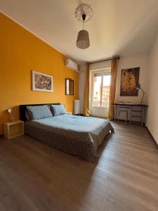 ein Schlafzimmer mit einem Bett und einem Tisch und einem Fenster in der Unterkunft Milano da Me - Ampio appartamento con 2 camere da letto in Mailand