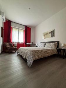 ein Schlafzimmer mit einem großen Bett mit roten Vorhängen in der Unterkunft Milano da Me - Ampio appartamento con 2 camere da letto in Mailand