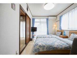 a bedroom with two beds and a mirror and a television at La Mer Urayasu - Vacation STAY 11148 in Urayasu