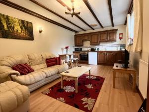 a living room with a couch and a table at Deanwood Holiday Cottages in Yorkley