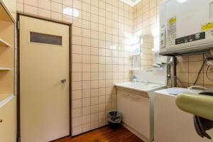 a small bathroom with a sink and a door at ISHIGAKI HOUSE - Vacation STAY 32172v in Ishigaki Island +41 photos