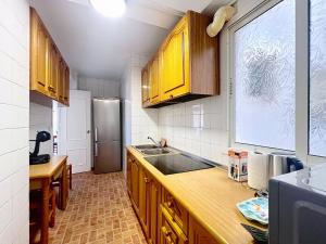ネルハにあるApartamento Sol en el centro de Nerjaのキッチン(木製キャビネット、ステンレス製の冷蔵庫付)