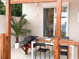 un patio con tavolo e sedie su un portico di KR base Villa IzuShirahama Resort - Vacation STAY 33293v a Shimoda