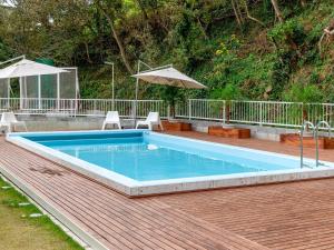 una piscina su una terrazza con sedie e ombrellone di KR base Villa IzuShirahama Resort - Vacation STAY 33293v a Shimoda