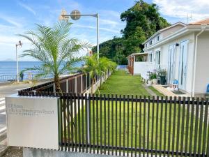 einen Zaun vor einem Haus am Meer in der Unterkunft KR base Villa IzuShirahama Resort - Vacation STAY 33296v in Shimoda