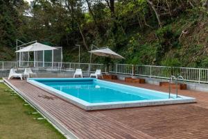 ein Swimmingpool mit zwei Stühlen und einem Sonnenschirm in der Unterkunft KR base Villa IzuShirahama Resort - Vacation STAY 33296v in Shimoda