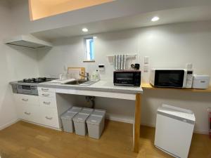 eine Küche mit einer Theke mit Spüle und Mikrowelle in der Unterkunft KR base Villa IzuShirahama Resort - Vacation STAY 33296v in Shimoda + 14 Fotos