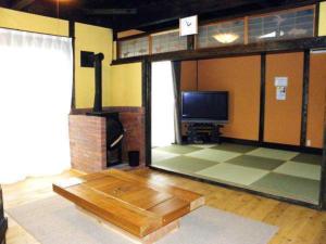 a living room with a flat screen tv and a large window at Log house for 12 people - Vacation STAY 35074v in Minamioguni