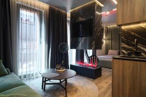 a living room with a fireplace and a couch and a table at Victory Love Apartaments! in Klaipėda