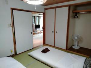 a room with a bed with a hat and a fan at Bay View House - Vacation STAY 17471 in Otaru