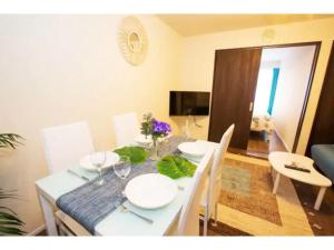 einen Esstisch mit weißen Tellern und Stühlen in der Unterkunft Hill Top Hakone Iryuda 202 - Vacation STAY 11214 in Odawara