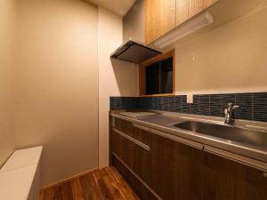 a small kitchen with a sink and a microwave at WABISABI ISURUGI KASHIWAYA - Vacation STAY 34839v in Oyabe