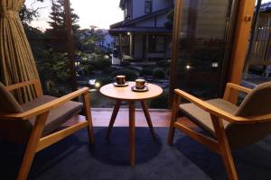 two chairs and a table with two coffee cups on it at WABISABI ISURUGI KASHIWAYA - Vacation STAY 34839v in Oyabe +30 photos