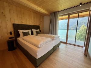 a bedroom with a bed with a large window at AquaVista Lakeside Apartments in San Valentino alla Muta