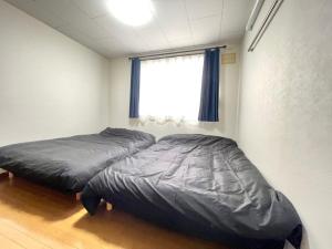 two beds in a bedroom with a window at Avidasion - Vacation STAY 13343 in Biei