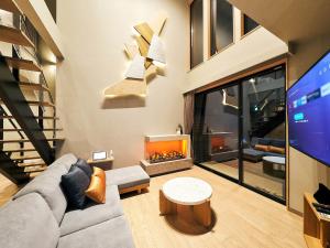 a living room with a couch and a tv at Rakuten STAY VILLA Hakone Sengokuhara North Wing 105 or 106 BBQ Terrace Pet allowed Capacity of 10 persons in Hakone