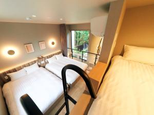 a room with two beds and a balcony at Rakuten STAY VILLA Hakone Sengokuhara North Wing 105 or 106 BBQ Terrace Pet allowed Capacity of 10 persons in Hakone