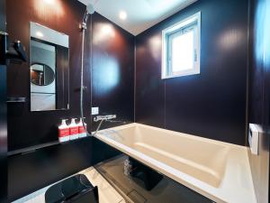 a bathroom with a large tub and a window at Rakuten STAY Hakata Gion 101 Superior Room in Fukuoka +46 photos