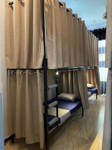 a row of bunk beds in a room with curtains at Happy Bunk Hostel Weligama in Weligama