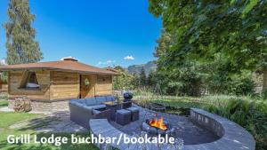 a backyard with a gazebo and a fire pit at Gartenhotel Rosenhof bei Kitzbühel in Oberndorf in Tirol