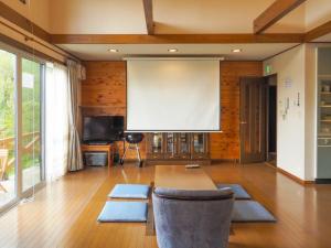 a large projection screen in a room with a table and chairs at Rigeru - Vacation STAY 11338 in Nasu