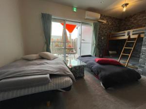 two beds sitting in a room with a window at Hotel Yua - Vacation STAY 40741v in Nago