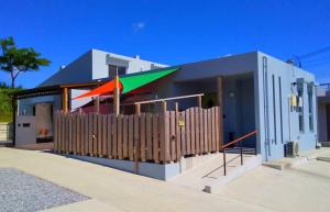 a house with a fence and a colorful umbrella at Hotel Yua - Vacation STAY 40741v in Nago