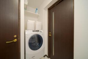 a washer and dryer in a room with a door at Tabi no yado Hanakeshiki Jinchoge 1st floor - Vacation STAY 42964v in Yufuin