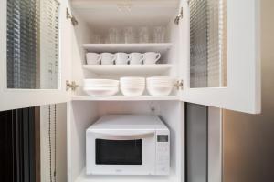 a kitchen with a white microwave and white dishes at Tabi no yado Hanakeshiki Ume 3rd floor - Vacation STAY 42983v in Yufuin