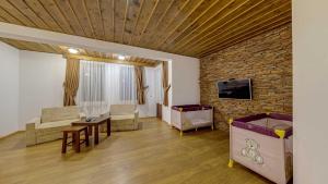 a living room with a brick wall and a tv at Комплекс Стара Плиска in Pliska