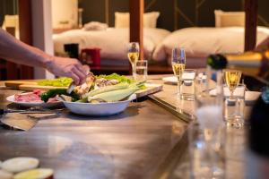 淡路市にあるAwaji Villa Forest - Vacation STAY 44333vの食卓の上で料理をする者