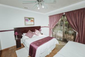 a bedroom with two beds and a window at CASTLE WITH A VIEW in Bloemfontein