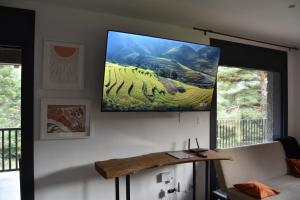 a flat screen tv hanging on a wall above a couch at Cal Manubens in Castellar del Riu