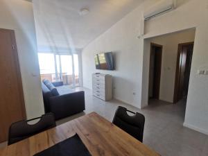 a living room with a table and a couch at Apartments Golub in Cesarica