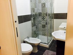 a bathroom with a toilet and a sink and a shower at Little Home in Trani