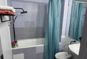 a bathroom with a blue shower curtain and a sink at Charmant T2 Lumineux Spacieux Vieux Cocody Centre in Abidjan +8 photos