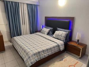 a bedroom with a bed with a checkered blanket and pillows at Charmant T2 Lumineux Spacieux Vieux Cocody Centre in Abidjan