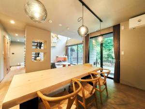 a dining room with a large wooden table and chairs at Rakuten STAY VILLA Hakone Sengokuhara North Wing 104 BBQ Terrace with Massage Chair capacity of 10 persons in Hakone