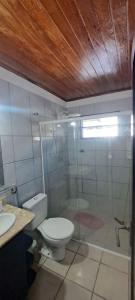 a bathroom with a toilet and a glass shower at Appartamento mobiliado in Natal +14 photos