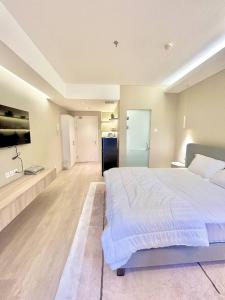 a large bedroom with a large bed and a tv at Apartement Podomoro Liberty Tower in medan Barat in Medan