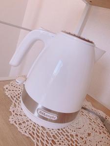 a white tea kettle sitting on top of a rug at Picoro Hakata - Vacation STAY 11327 in Fukuoka