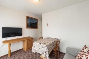 a small living room with a table and a television at Dolomitohouse PEZ in Fiera di Primiero +46 photos