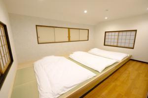 a bedroom with a large bed with white sheets at iORi Yufuin - Vacation STAY 42351v in Yufuin