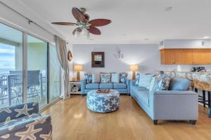 un soggiorno con divani blu e un balcone di Oceanside 302 a Clearwater Beach