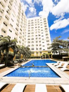 a large swimming pool in front of a large building at JFam Suites, C4-11K Studio, Up To 4 Pax in Biñan