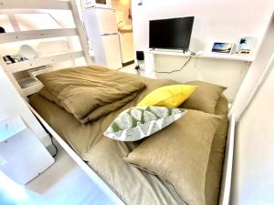 a bed with pillows on it in a room at Le Soleil Asato - Vacation STAY 48649v in Naha