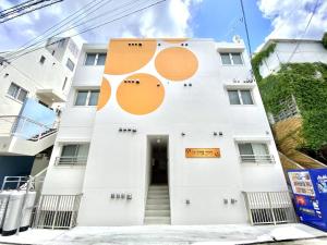a white building with orange circles on it at Le Soleil Asato - Vacation STAY 48649v in Naha