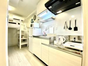 a kitchen with white cabinets and a counter top at Le Soleil Asato - Vacation STAY 48615v in Naha