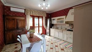 a kitchen with red walls and a white table and chairs at Rome Charm House in Marino
